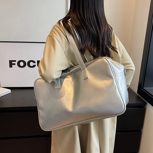 Large silver minimalist tote bag with NOCO lettering carried by model in trench coat