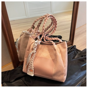 Detail of pink canvas tote featuring heart embossed texture and braided rope handles