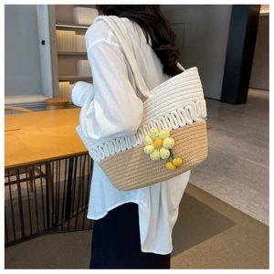 Detail of hand-woven tote bag featuring cream and brown two-tone design with sunflower charm