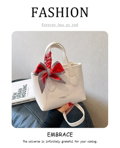 Close-up of cream mini tote bag featuring textured leather and a plaid silk scarf