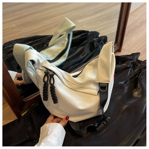 Détail du sac croissant en nylon blanc avec tirette tressée et sangle à boucle