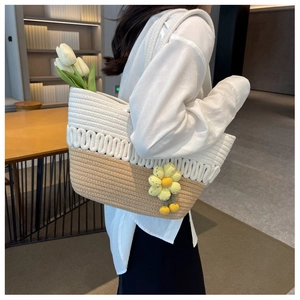 Detail of hand-woven tote bag with beige-khaki texture and crochet flower charm