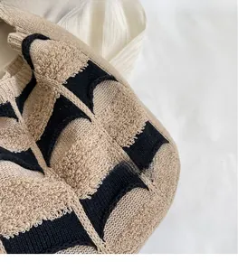 Détail d'un sac cabas en maille épaisse avec motif géométrique noir et beige
