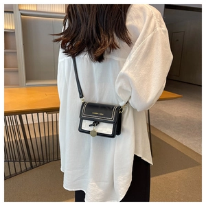 Dettaglio di una borsa a tracolla chic in bianco e nero con rivetti dorati