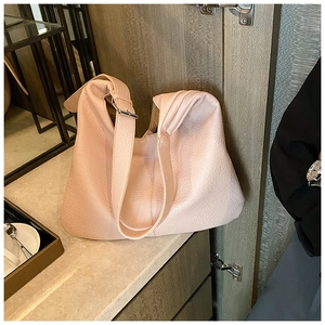 Close-up of pink litchi grain leather tote bag with silver buckle and wide strap