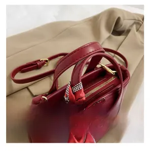 Detail presentation of dark red leather bucket bag with silk scarf on the handles