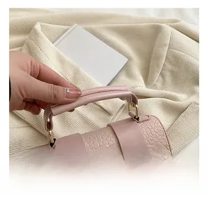 Détail de la poignée renforcée d'un petit sac carré rose à motif crocodile élégant