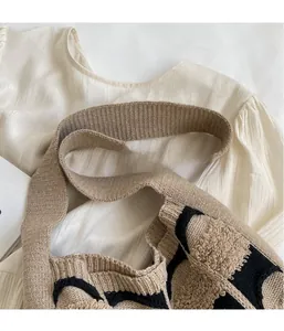 Vue détaillée du sac cabas rétro en tricot de coton beige avec motifs géométriques noirs