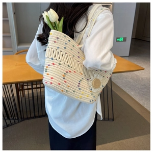 Close-up of woven tote bag featuring colorful polka dots and a 3D floral accent
