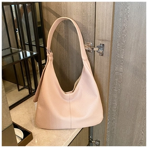 Detailed texture of light pink hobo bag featuring pebbled leather and metal buckle