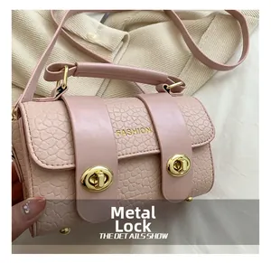 Détail du sac rose texture crocodile avec fermoir doré et logo Fashion gravé