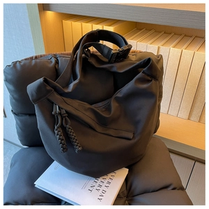 Détail du sac messager en nylon noir avec bandoulière réglable et tirettes tressées
