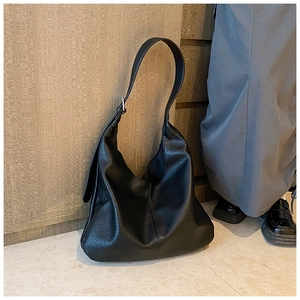 Close-up of a large black hobo tote bag with soft lychee texture leather and strap
