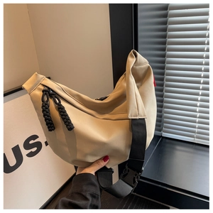 Détail du sac croissant en nylon beige avec fermeture éclair noire et sangle