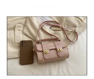 Détail du sac bandoulière rose embossé crocodile avec comparaison de taille au téléphone