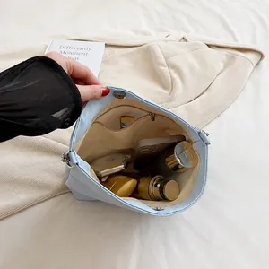 Macro shot showing internal storage and zipper pocket of the light blue bucket bag