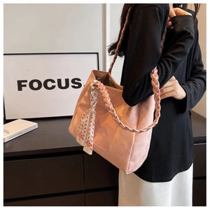 Pink tote bag detail with heart embossing, woven handles and decorative scarf accessory