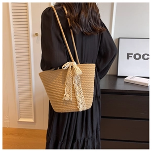 Detail shot of woven tote bag with white lace bow decoration and sturdy double handles