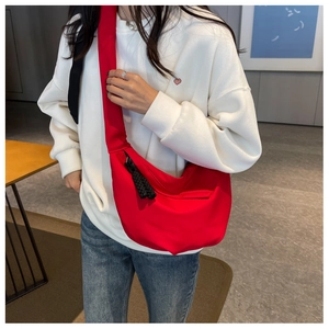 Détail du sac croissant en nylon rouge avec tirette en corde tressée noire mate