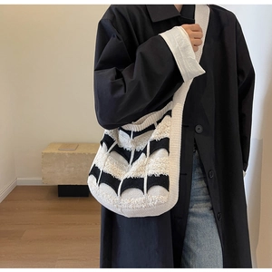 Détail d'un grand sac en tricot avec motifs à vagues noirs et blancs et large bandoulière