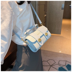Détail du sac bandoulière bleu et beige avec texture croco et texte FASHION doré