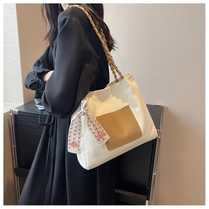 Detail of white canvas tote bag featuring heart textures and silk scarf decoration
