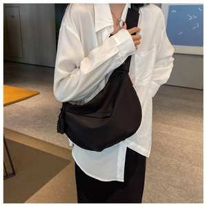 Mannequin portant un grand sac croissant en nylon noir avec bandoulière minimaliste