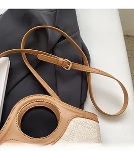 Détail de la bandoulière réglable et boucle en métal sur sac seau bicolore chic