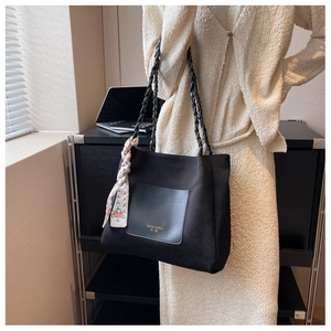 Detail of black canvas tote bag with heart pattern and elegant silk scarf accessory