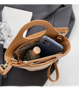Détail de la doublure rayée et de la poche zippée intérieure du sac seau marron spacieux