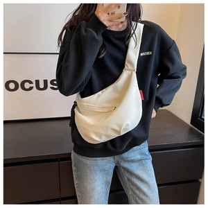 Détail du sac croissant en nylon blanc cassé avec texture imperméable et sangle latérale