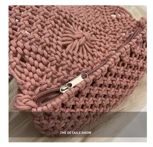Detailed close-up of smooth silver zipper and hand-woven texture on pink straw bag