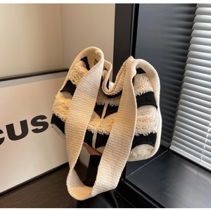 Détail du sac cabas tissé avec rayures noires et beige et texture bouclée douce