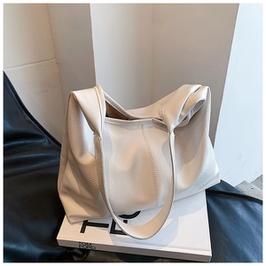 Détail d'un grand sac fourre-tout blanc cassé montrant la texture du cuir souple naturel