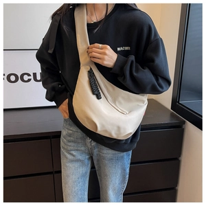 Vue détaillée d'un sac demi-lune en nylon beige avec pendentif de fermeture tressé