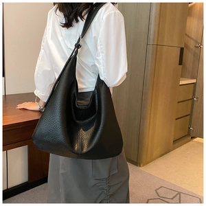 Close-up of black lychee grain leather hobo bag showing texture and wide strap detail