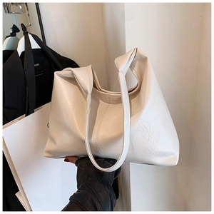 Détail d'un grand sac cabas crème avec texture plissée douce et doubles anses d'épaule