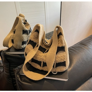 Détail du sac cabas tissé rayé kaki et noir avec une finition texturée en maille bouclée