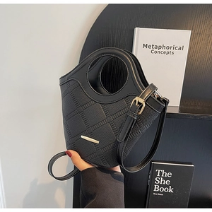 Détails du sac seau noir en cuir foulonné avec matelassage et poignée ronde