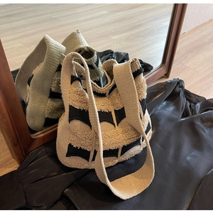 Gros plan du sac fourre-tout en tricot beige et noir avec texture 3D et motif ondulé