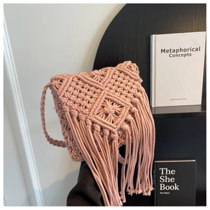 Detailed view of pink hand-woven crochet shoulder bag with bohemian long fringe tassels