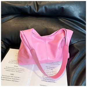 Vue détaillée de la texture du cuir plissé rose d'un sac seau souple à bandoulière
