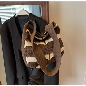 Détail du sac cabas en tricot avec des rayures marron et crème et une texture douce