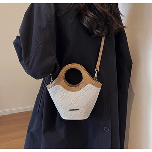 Détail d'un mini sac seau tissé beige avec garniture marron et accent métallique