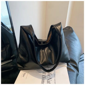 Gros plan sur le sac hobo en cuir PU brillant noir avec fermeture magnétique et bandoulière