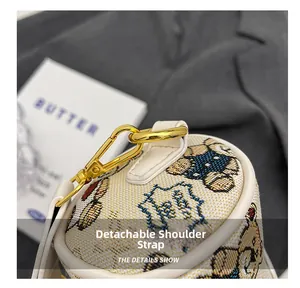 Détail de la bandoulière amovible en cuir blanc avec une boucle en métal doré
