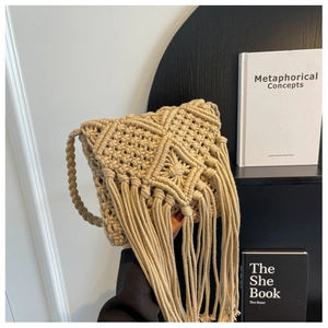 Detailed close-up of bohemian woven cotton bag with tassel accents and geometric texture