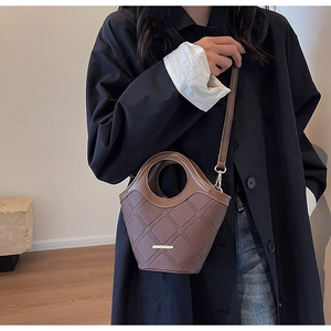 Vue détaillée du sac seau en cuir marron avec motifs géométriques et poignée intégrée