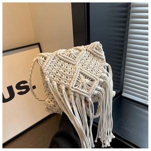 Detailed close-up of Bohemian handmade woven cotton bag with geometric patterns and long tassels