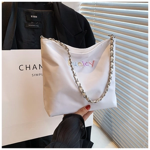 Detail der weißen Oxford-Beuteltasche mit Lucky-Stickerei und Metallkettenriemen